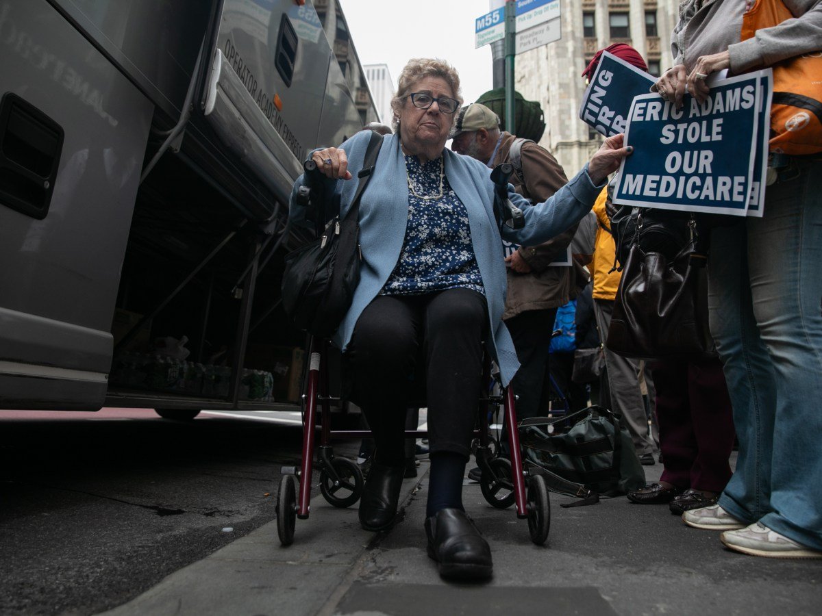 City retiree Merritt Claude sits in her walker before boarding a bus up to Albany.