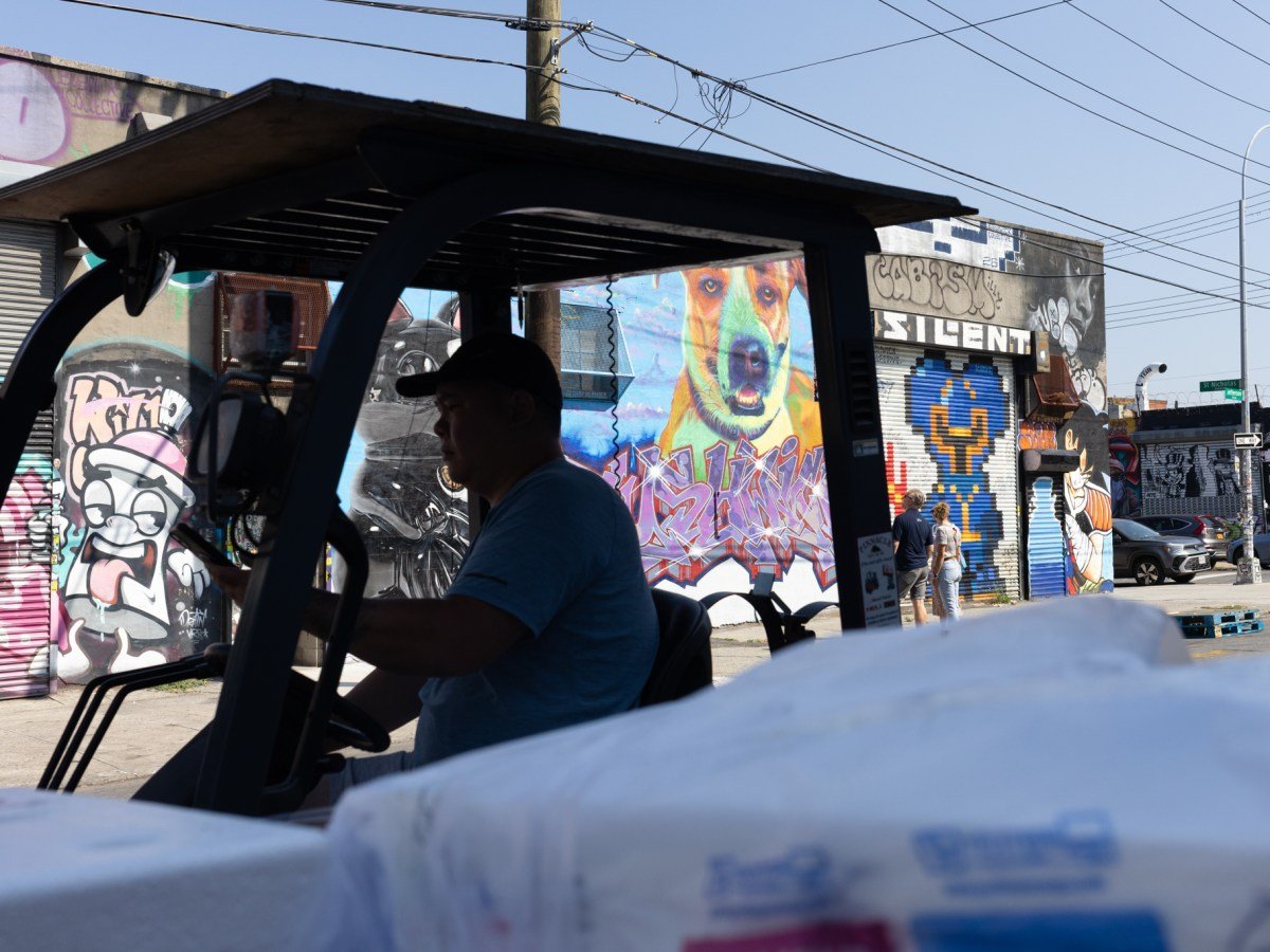 A worker drives a forklift in an industrial part of Bushwick,