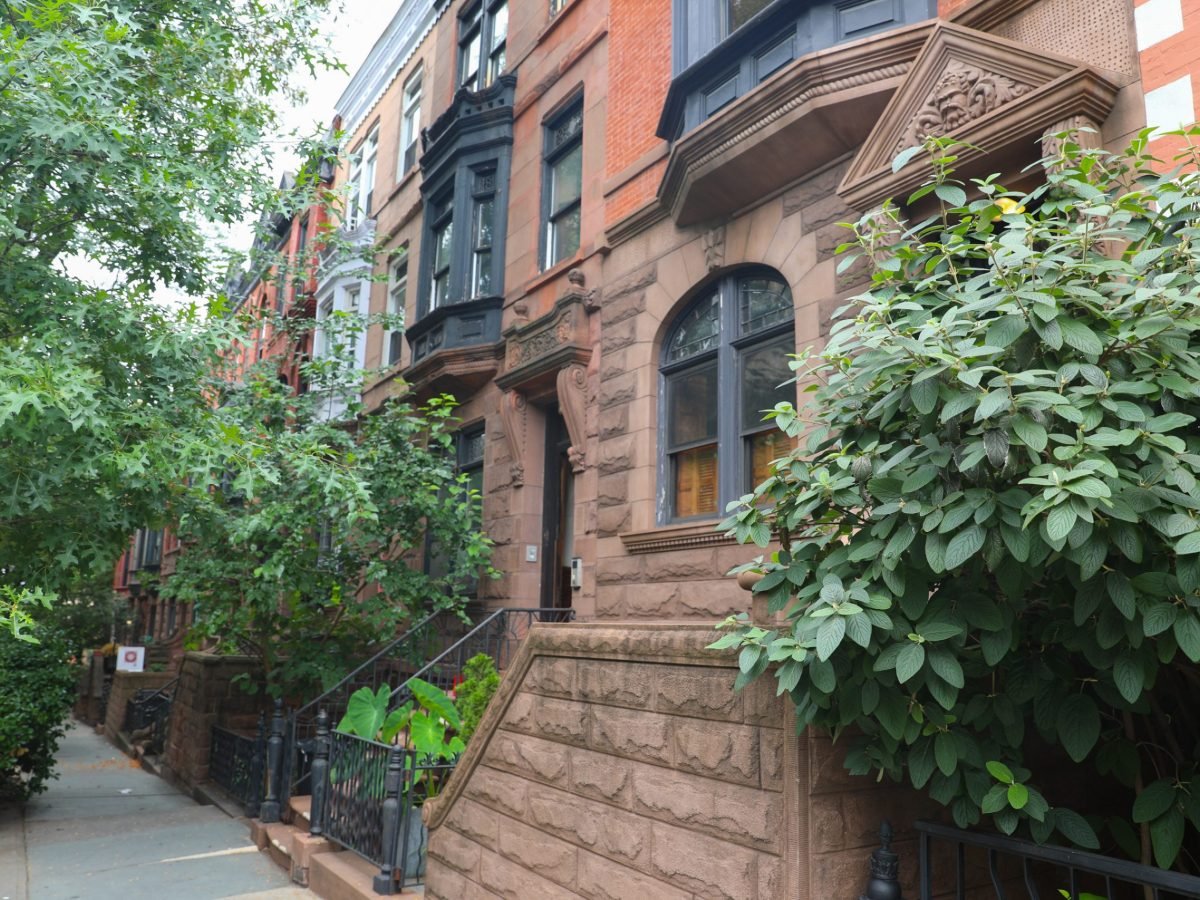 Brownstones line a leafy Upper West Side residential block.